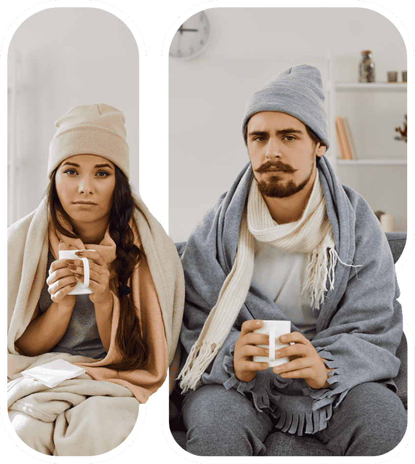 couple sitting in cold house covered with blankets and holding warm beverage